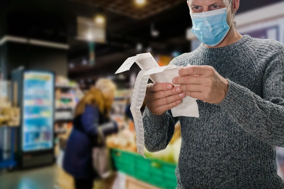 Male customer doing grocery shopping at supermarket and feeling confused by bill