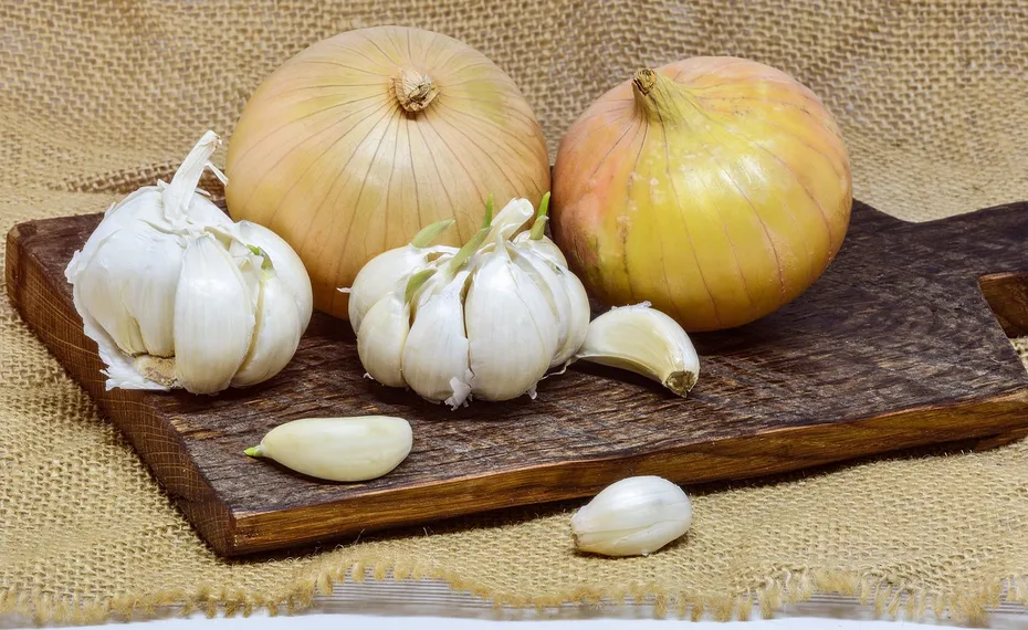 garlic and onions on a wooden board