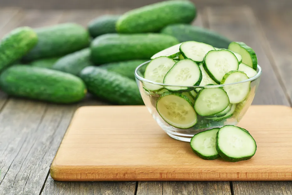 chopped fresh cucumber slices in a clear glass bowl on a wooden table