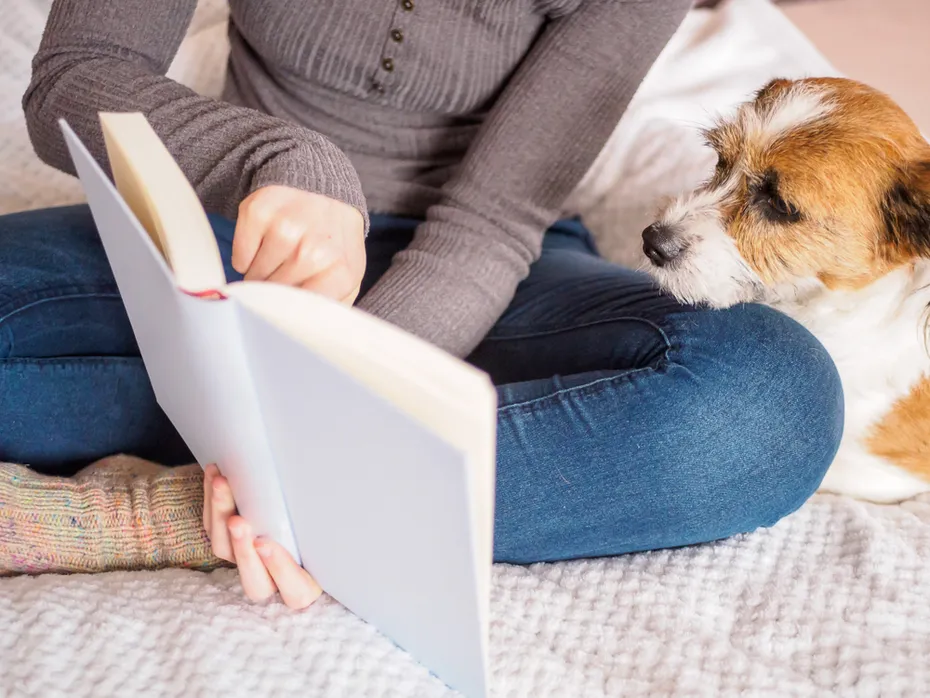 woman reading a book to her dog