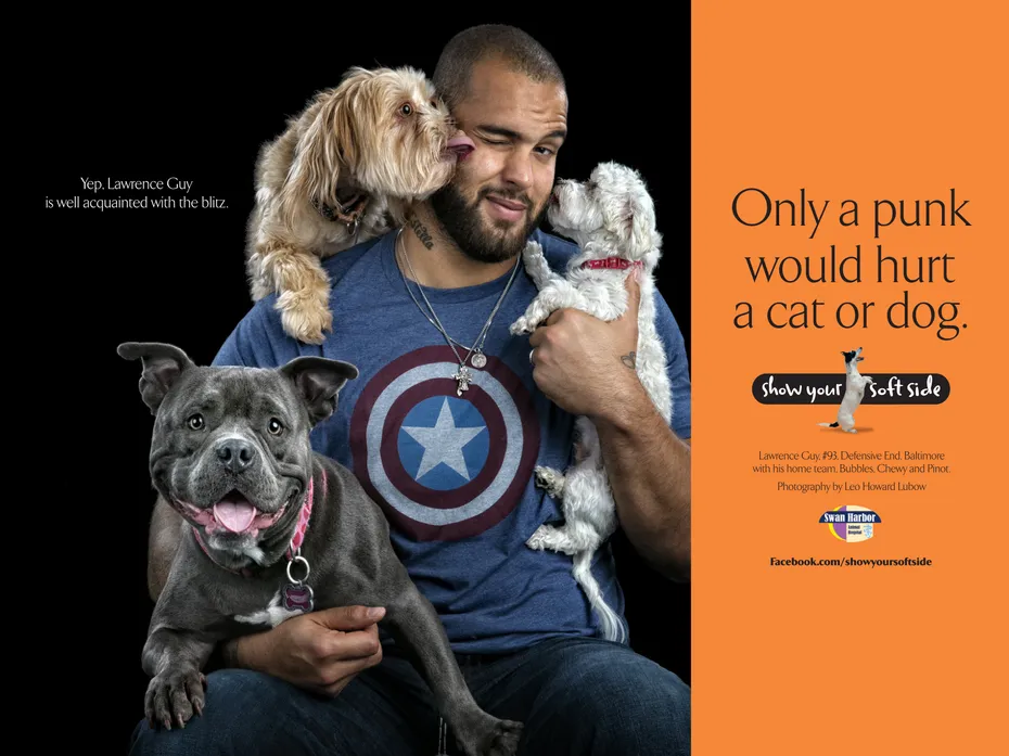 Lawrence Guy winking while holding three dogs for an animal rescue ad