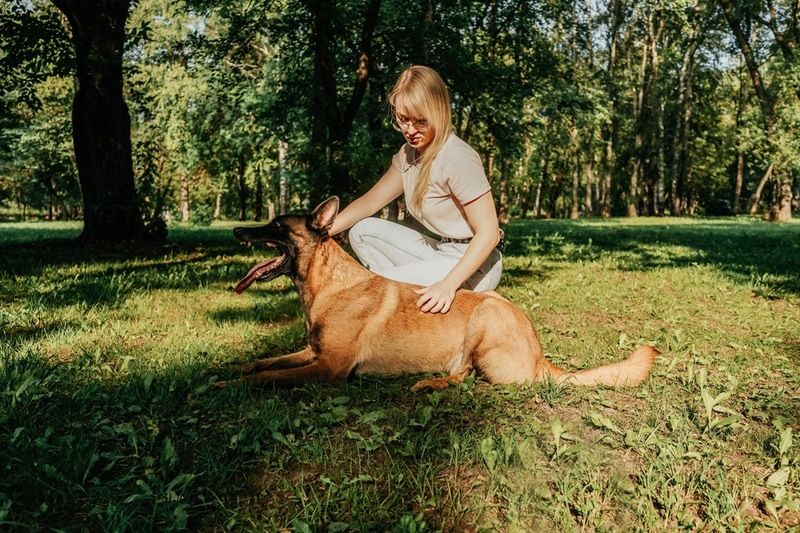 woman with belgian malinois at the park