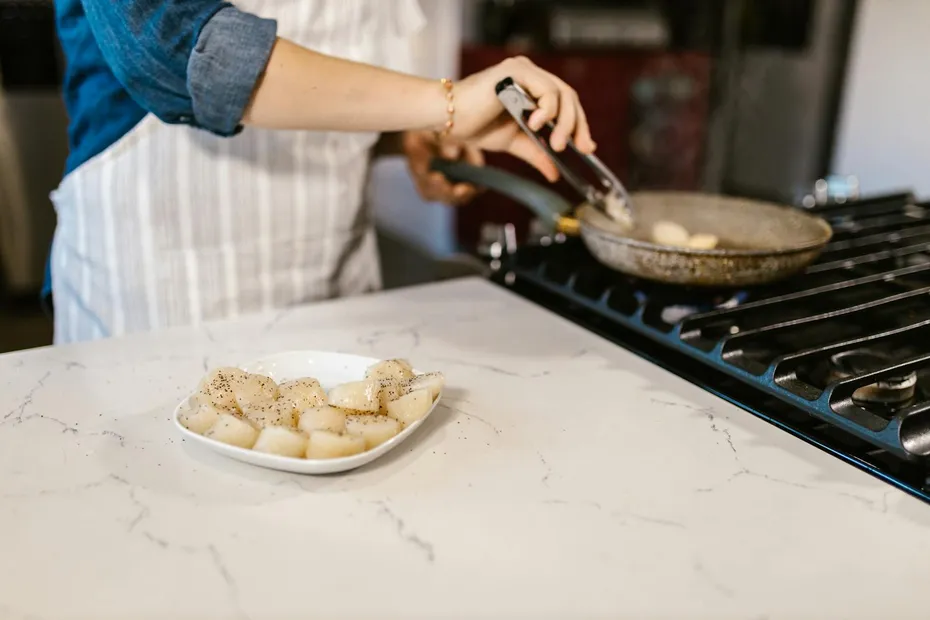 Plateful of Scallops Prepared for Frying on Gas Cooker