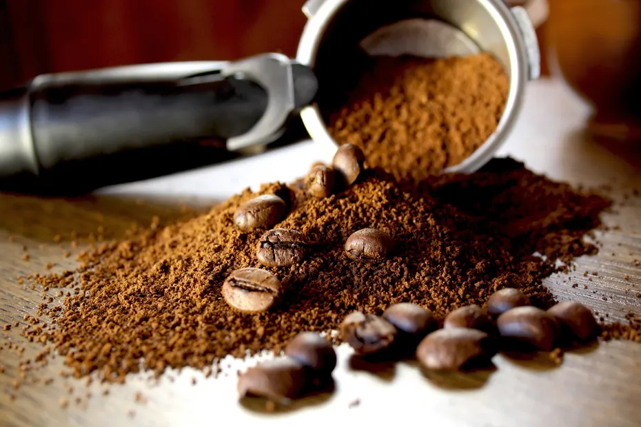 ground coffee and beans on wooden background