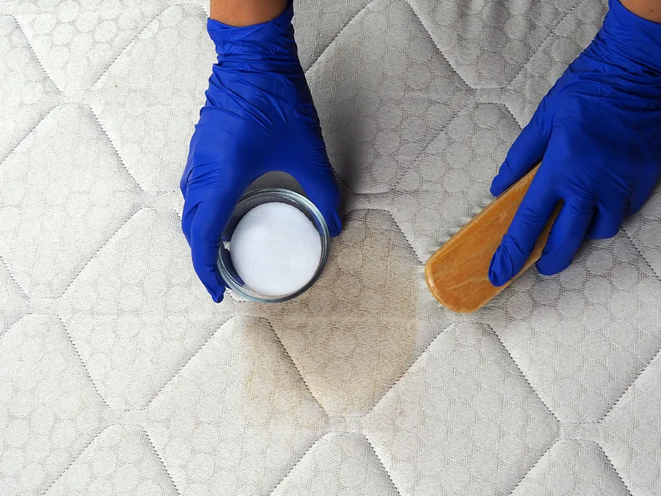 person spot cleaning the mattress