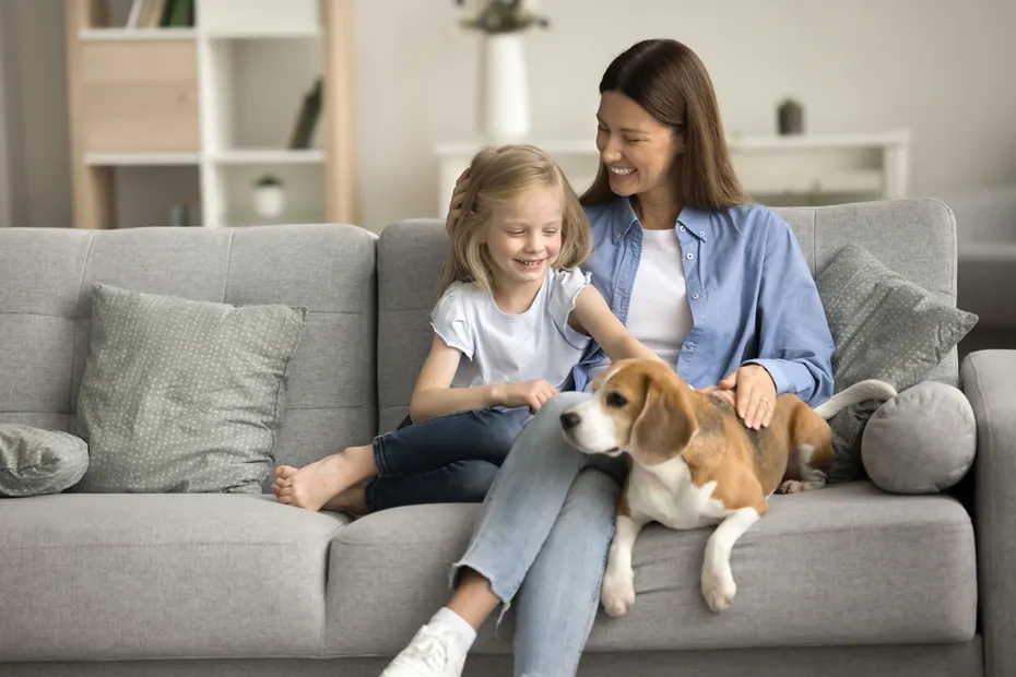 mom and daughter bonding on couch with their dog