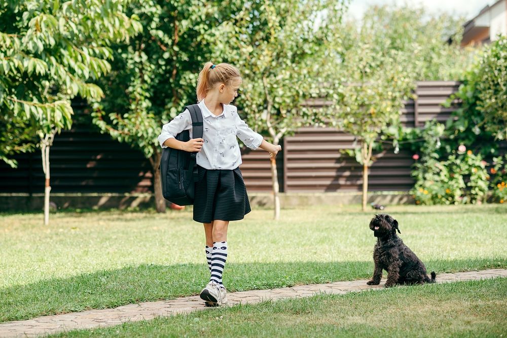 Girl going to school saying bye to her dog