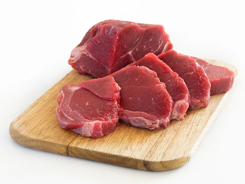 slices of beef on wooden chopping board