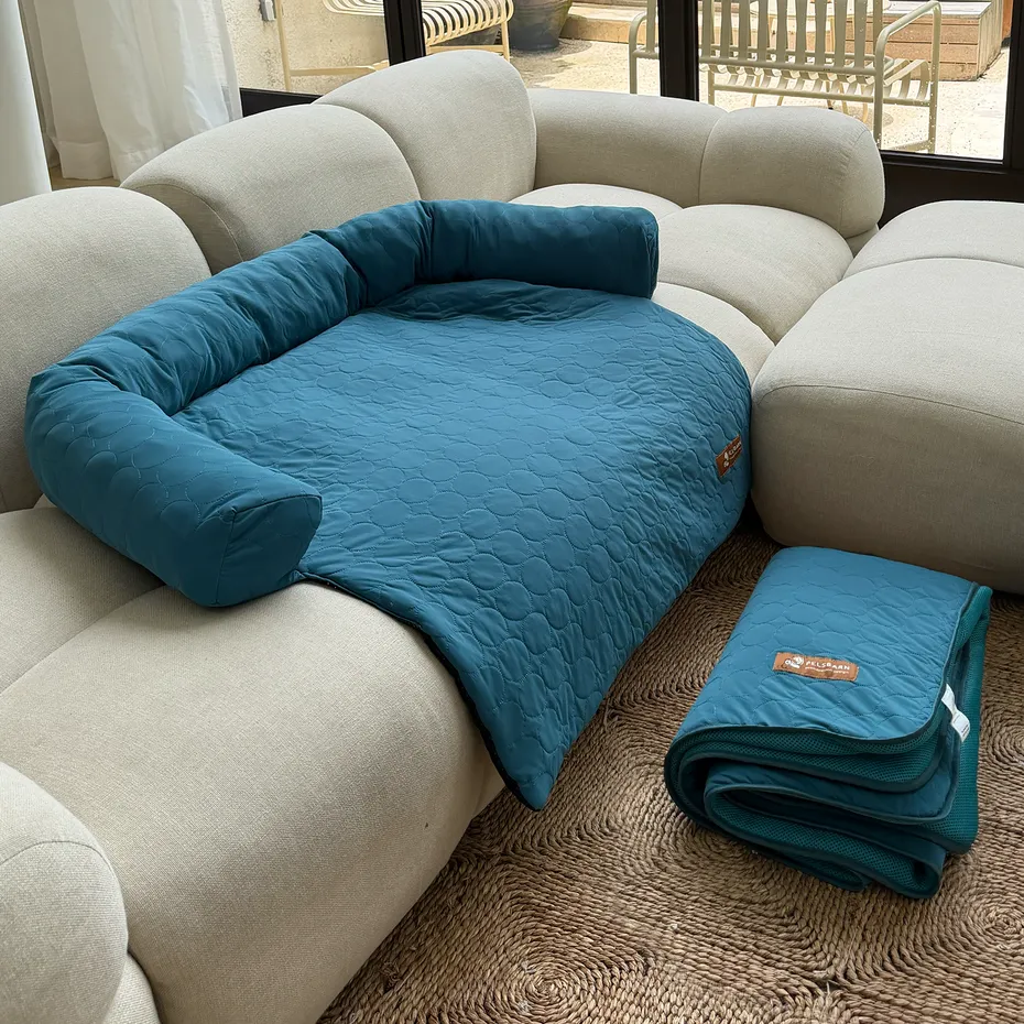 Teal quilted Pelsbarn cooling dog bed on a sofa and folded on the floor