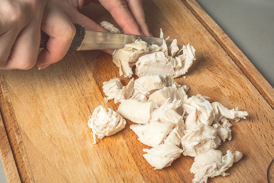 person chopping boiled chicken