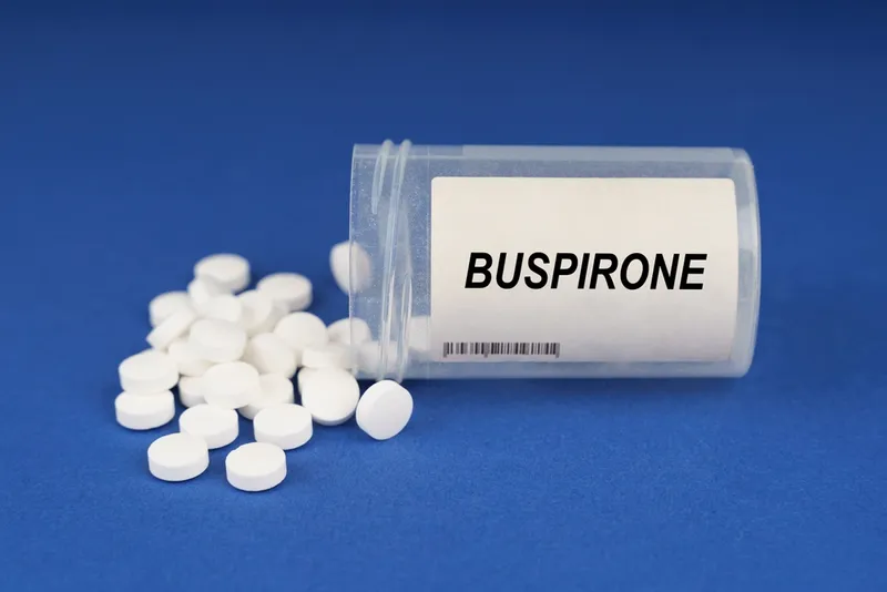 On a blue surface are pills and a dusty jar with the inscription