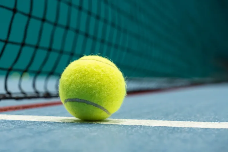 Tennis ball on blue tennis court