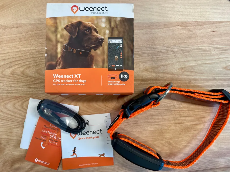 Weenect XT GPS dog tracker box, manual, charging cable, and orange collar