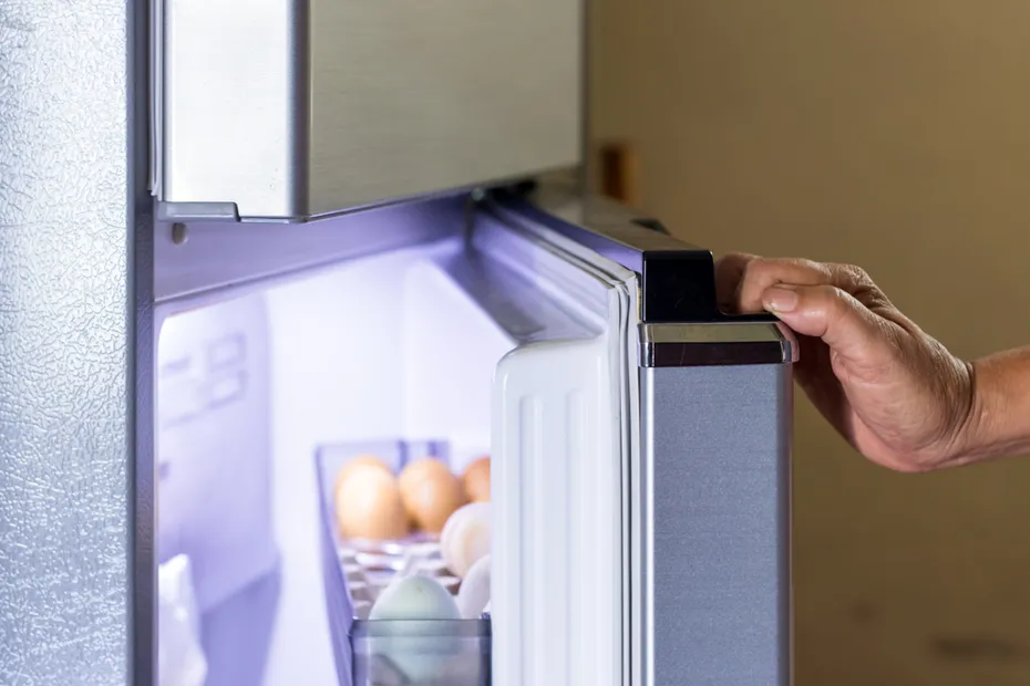 woman opening a gray refrigerator door