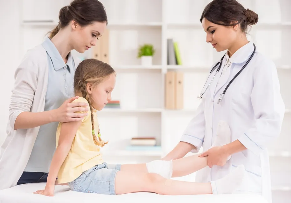 Pediatrician-doctor-bandaging-childs-leg
