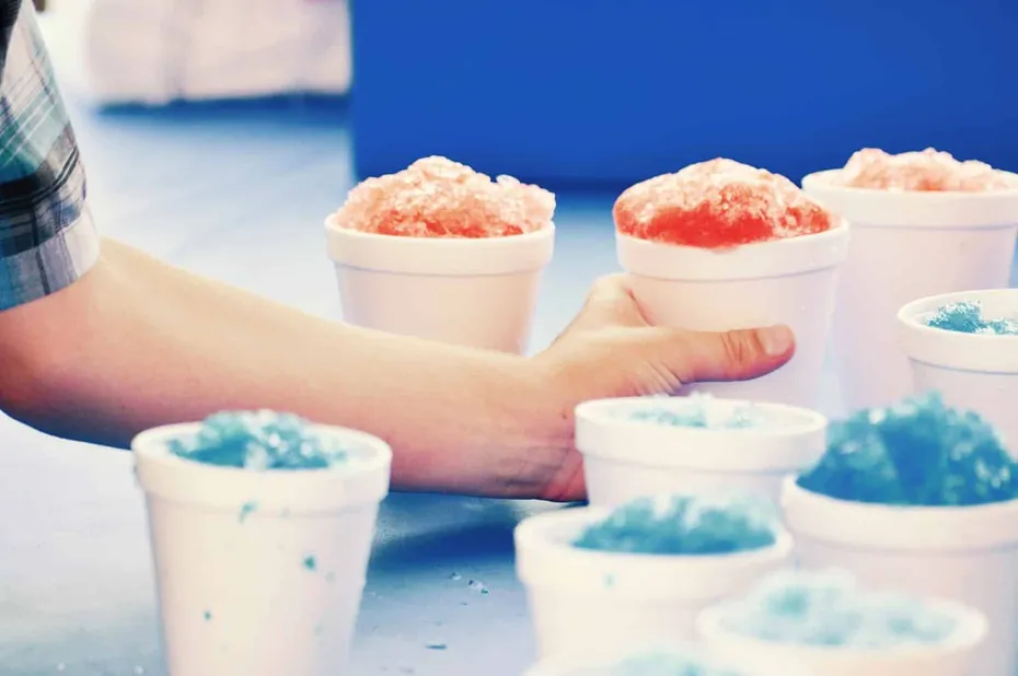 man handling snow cones on a table