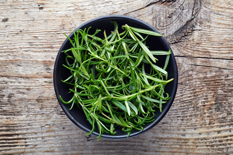 Bowl of rosemary on wooden table
