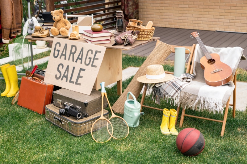 Various things placed on table and chairs in a garage sale
