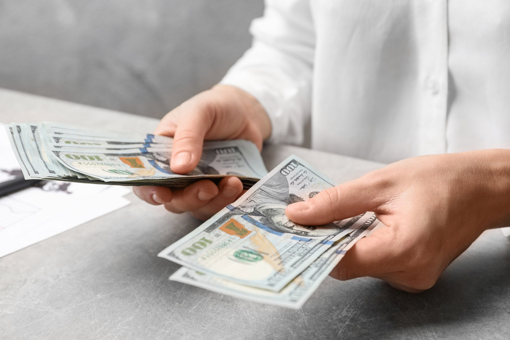 woman counting dollars at the table