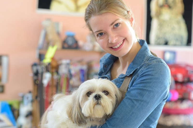 young woman and her dog in pet store