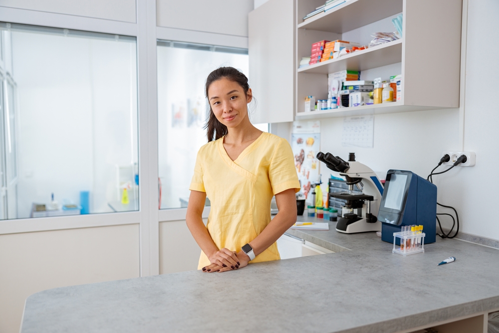 Young vet assistant stands at workplace in animal clinic
