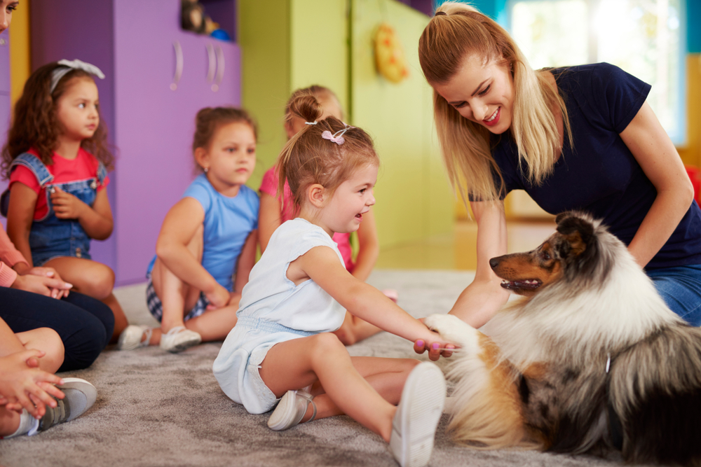 happy child playing with dog in a classroom