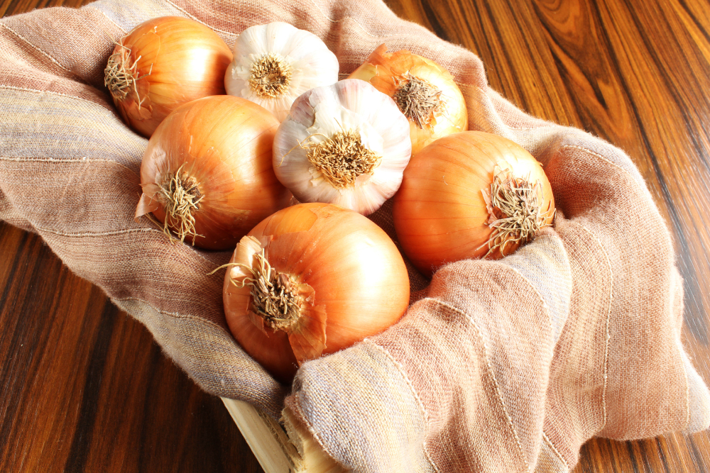 Garlic bulbs and onions in the wooden box