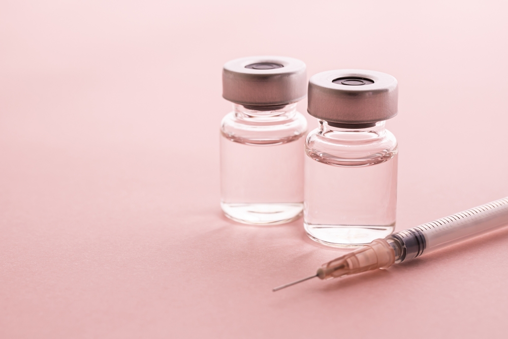 syringe and vial on pink background