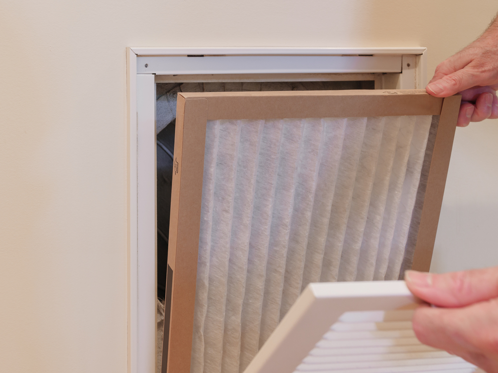 HVAC service technician replacing filter